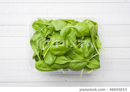Fresh spinach leaves in a plate on a light table. Fresh spinach leaves in a plate on a light table. 46693653