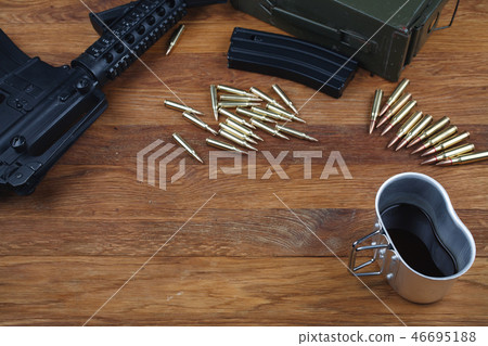 rifle and cup of coffee on wooden table rifle and cup of coffee on wooden table 46695188