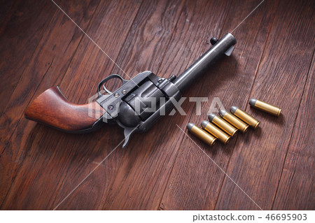 Old revolver with cartridges 46695903