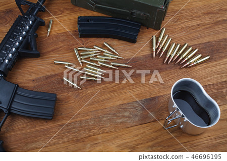 assault rifle and cup of coffee on wooden table assault rifle and cup of coffee on wooden table 46696195