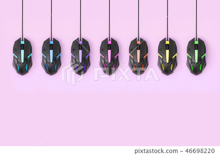 Black computer mouses hang on pink background Black computer mouses hang on pink background 46698220