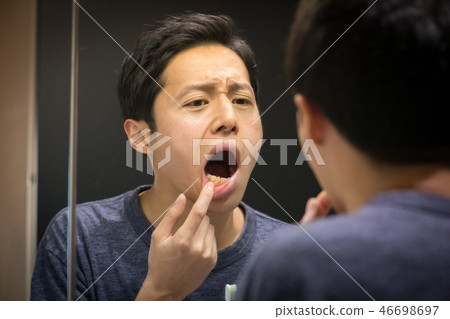 Young Japanese Man Looking at the Mirror Stomatitis Periodontal Disease 46698697
