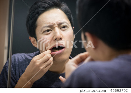 Young Japanese Man Looking at the Mirror Stomatitis Periodontal Disease 46698702