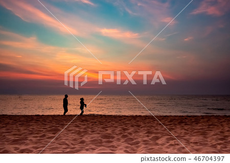 silhouette couple walking on beach silhouette couple walking on beach 46704397