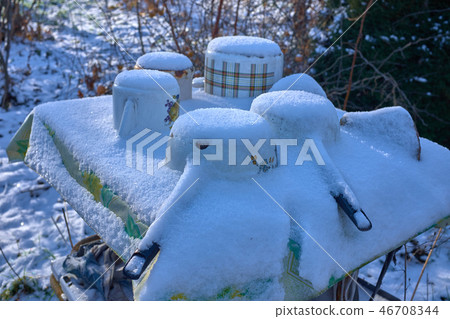 Frozen Old rusty cast metal Casseroles on a table under the snow during the winter. Frozen Old rusty cast metal Casseroles on a table under the snow during the winter. 46708344