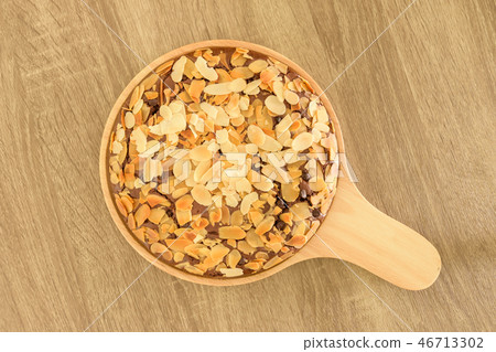 Brownie with almond on wood plate. 46713302