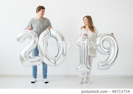 New year, celebration and holidays concept - funny love couple holding sign 2019 made of silver 46713754