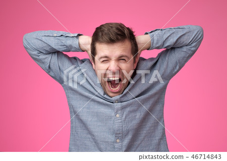Young man covering his ears and shouting. Young man covering his ears and shouting. 46714843