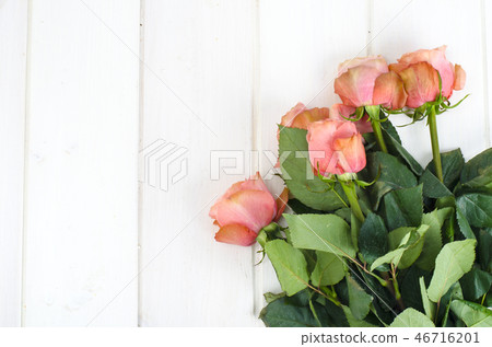 Pink roses on white wooden table Pink roses on white wooden table 46716201
