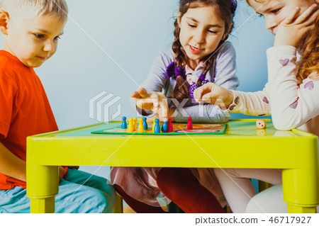 Close view of children faces around table with board game 46717927