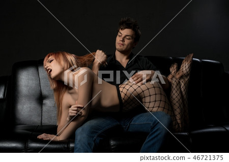 Beautiful lovers relaxing on a sofa in the dark 46721375