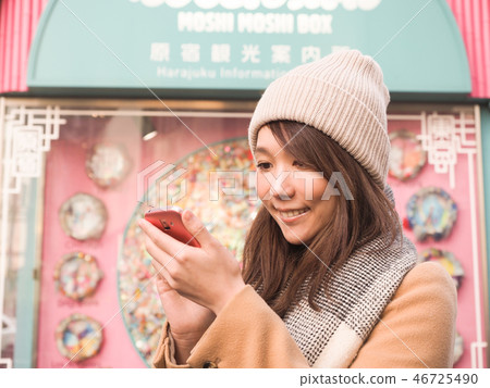Woman operating a smartphone 46725490