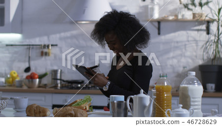 Woman using her tablet in the kitchen 46728629
