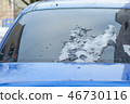 The rear glass of the car with snow residues that melted during the winter's thaw. 46730116