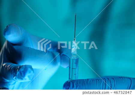 Physician injector arms in sterile uniform holding syringe Physician injector arms in sterile uniform holding syringe 46732847