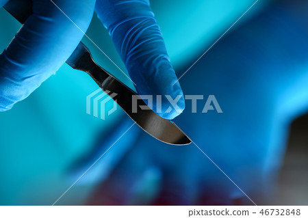 Surgeon arms in sterile uniform holding sharp knife Surgeon arms in sterile uniform holding sharp knife 46732848