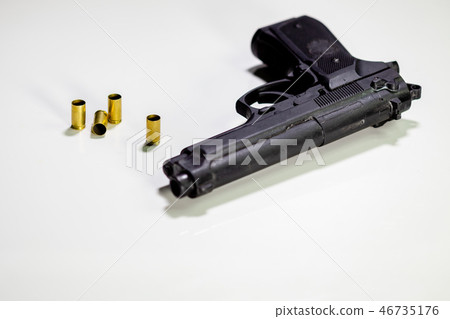 Handgun with 9mm shell casings on white table Handgun with 9mm shell casings on white table 46735176
