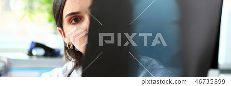 Female beautiful doctor hold in arm and look at xray Female beautiful doctor hold in arm and look at xray 46735899