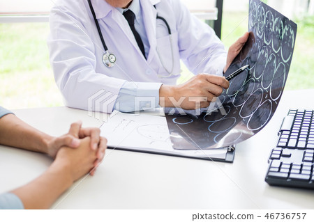 doctor analyzing a scan or x-ray film or explains a CT scan thou doctor analyzing a scan or x-ray film or explains a CT scan thou 46736757