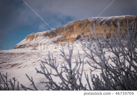 Winter landscape of snow-covered cliffs of the plateau in the North Caucasus through the branches of Winter landscape of snow-covered cliffs of the plateau in the North Caucasus through the branches of 46739709