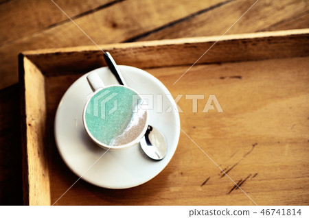top view of coffee cup on a white saucer and teaspoon on wooden background top view of coffee cup on a white saucer and teaspoon on wooden background 46741814