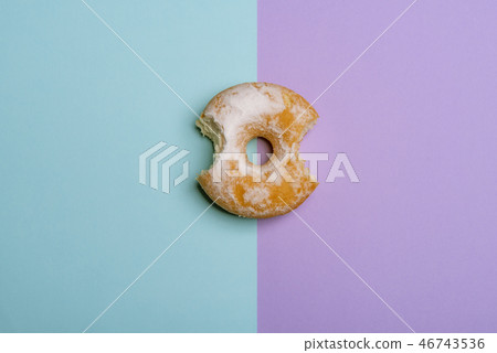 Bitten donut on blue-violet bicolored background 46743536