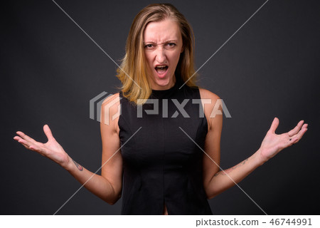 Young beautiful businesswoman with straight blond hair against g 46744991