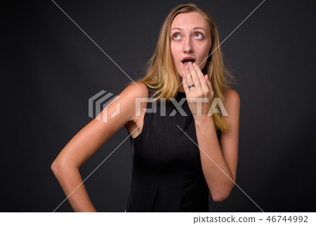 Young beautiful businesswoman with straight blond hair against g Young beautiful businesswoman with straight blond hair against g 46744992