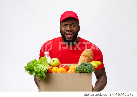 Young african american man holding grocery box in hands with shocking face. Isolated over Grey 46745172