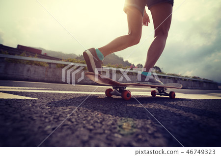 Skateboarder skateboarding on highway road Skateboarder skateboarding on highway road 46749323