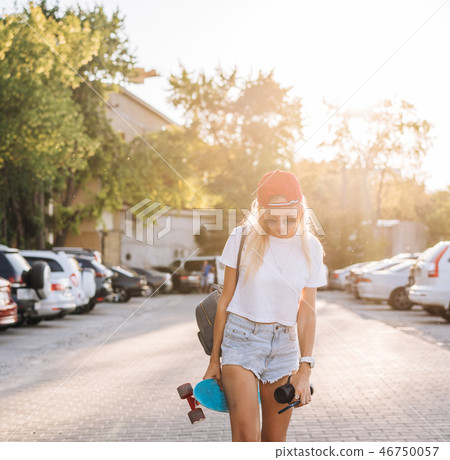 Young girl with a skateboard on a car park. Young girl with a skateboard on a car park. 46750057