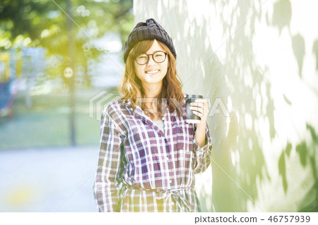 Woman drinking coffee in the park 46757939