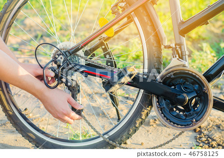 the guy repairs the bicycle. chain repair. cyclist 46758125