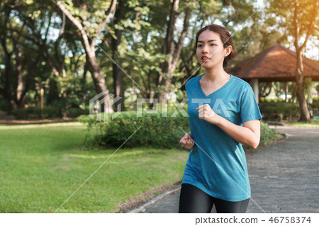 Young asian runner woman running in the park. Young asian runner woman running in the park. 46758374