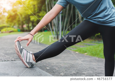 woman runner stretching arm and leg before running woman runner stretching arm and leg before running 46758377