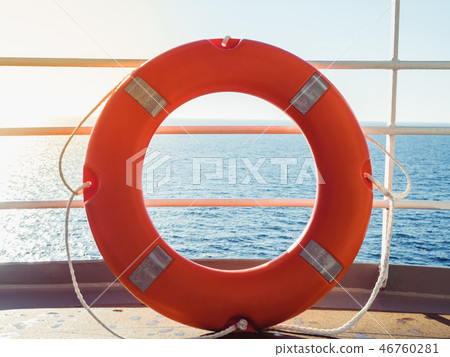 Bright, orange lifebuoy on the top deck of the cruise liner 46760281