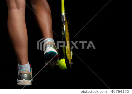 Beautiful girl tennis player with a racket on dark background with lights 46764100