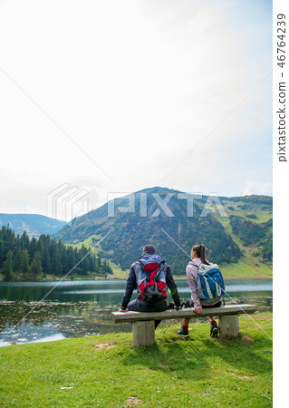 young couple of backpackers near the lake in mountains 46764239