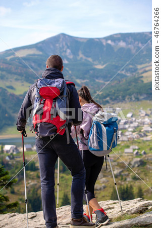 couple hiking in the mountain and enjoying view on the lake couple hiking in the mountain and enjoying view on the lake 46764266