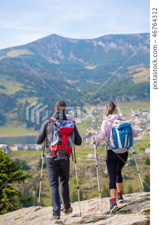 couple hiking in the mountain and enjoying view on the lake couple hiking in the mountain and enjoying view on the lake 46764312