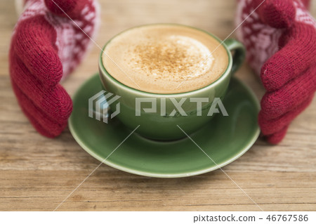Hand in glove holding coffee 46767586