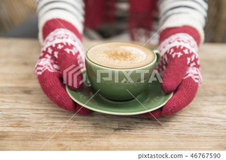 Hand in glove holding coffee 46767590