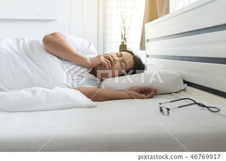 Elderly asian woman coughing and laying down Elderly asian woman coughing and laying down 46769917