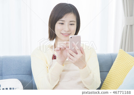 A young woman operating a smartphone 46771188