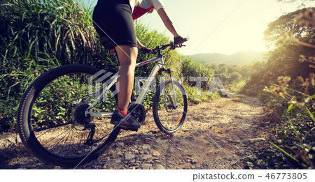 Woman cyclist riding a bike on a nature trail  46773805
