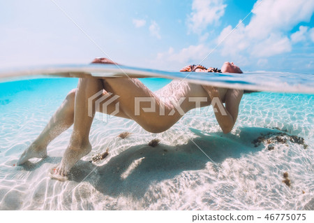 Nude woman floating and relax in tropical blue sea 46775075
