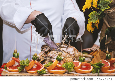 Show at restaurant: chief cook cuts pork thigh Show at restaurant: chief cook cuts pork thigh 46775764