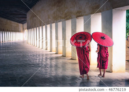 Two buddhist monk novice holding red umbrellas 46776219