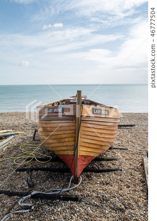 Wooden boat raised to gravel beach 46777504