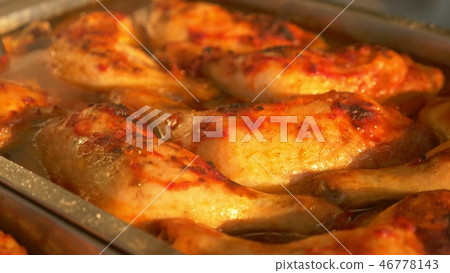 Close-up. Chicken legs in tomato sauce on a tray. 46778143